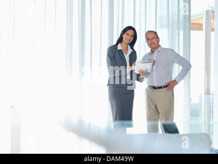 Geschäftsleute, die lächelnd im Büro Stockfoto