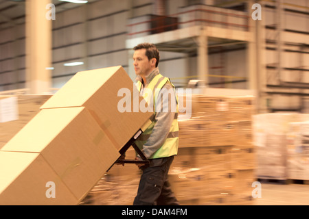 Arbeiter Kart Kisten im Lager Stockfoto