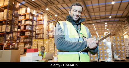 Arbeiter in Zwischenablage im Warehouse schreiben Stockfoto