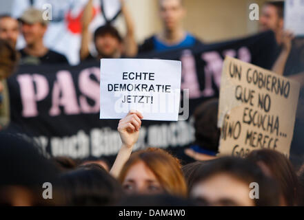 Eine Frau hält ein Schild "Echte Demokratie jetzt" ("echten Demokratie Jetzt") bei einer Kundgebung mit den andauernden Demonstrationen in Spanien vor dem Brandenburger Tor in Berlin, Deutschland, 21. Mai 2011. Unter dem Motto "Democracia Real Ya" viele Hunderte von Menschen wurden meist Spanier mobilisiert über Facebook am Pariser Platz zu sammeln, um für mehr Demokratie zu kämpfen. Foto: Fl Stockfoto
