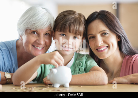 Drei Generationen von Frauen füllt Sparschwein Stockfoto