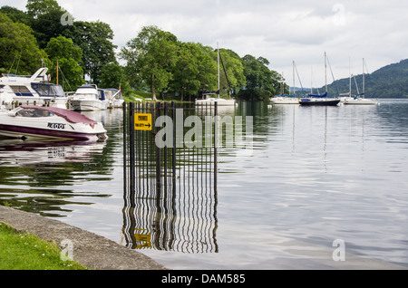 Eine See-Szene auf Windermere Wasserstand nach heftigen Regenfällen aufging. Einige Bäume, Boote und Yachten in der Ferne. Stockfoto