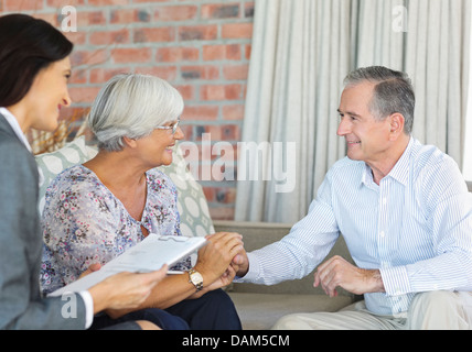 Finanzberater im Gespräch mit paar auf sofa Stockfoto