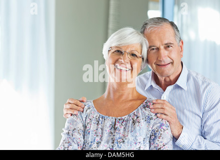 Älteres Ehepaar lächelnd zusammen drinnen Stockfoto