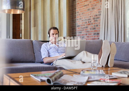 Mann mit Laptop auf dem Sofa Stockfoto