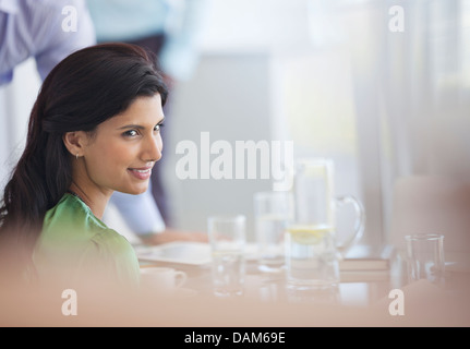 Geschäftsfrau, die lächelnd am Besprechungstisch Stockfoto