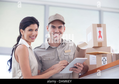 Frau, die Unterzeichnung für Pakete von Austräger Stockfoto