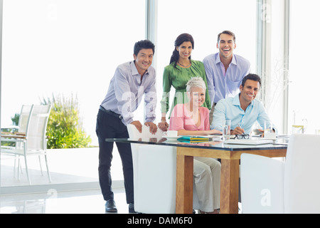 Geschäftsleute, die lächelnd zusammen im Büro Stockfoto