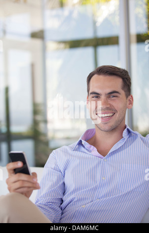 Geschäftsmann mit Handy im Büro Stockfoto