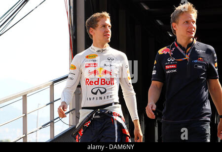 Deutsche Formel1-Fahrer Sebastian Vettel (L) von Red Bull Racing und seine Physio Tommi Parmakoski Spaziergang durch das Fahrerlager während des ersten Trainings auf dem Stadtkurs von Monte Carlo, Monaco, 26. Mai 2011. Am 29 Mai findet die Formel 1 Grand Prix von Monaco statt. Foto: Jens Buettner dpa Stockfoto