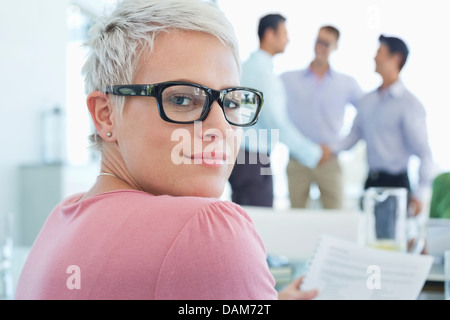 Geschäftsfrau, die lächelnd im Büro Stockfoto