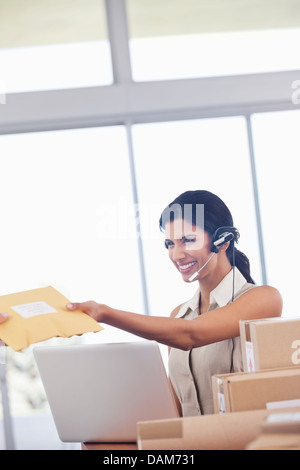 Geschäftsfrau, die Annahme der Pakete im Büro Stockfoto