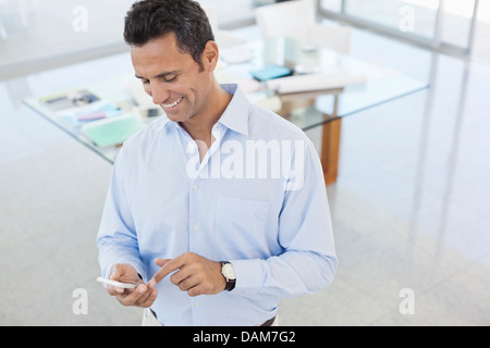 Geschäftsmann mit Handy im Büro Stockfoto