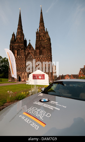 Kathedrale von Lichfield mit Banner bereit für das Jahr 2013 Lichfield Festival mit Motorhaube BMW Autos im Vordergrund. Stockfoto