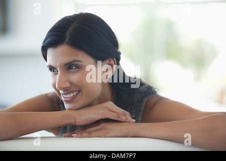 Frau ruht Kinn in die Hände auf sofa Stockfoto