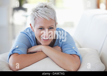Frau ruht Kinn in die Hände auf sofa Stockfoto
