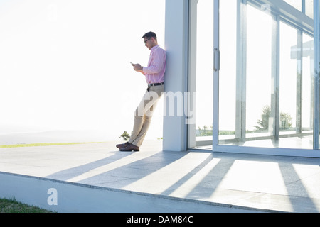 Geschäftsmann mit Handy außerhalb Büro Stockfoto