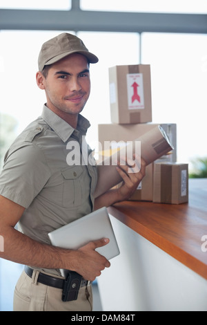 Austräger mit Paketen in Büro Stockfoto