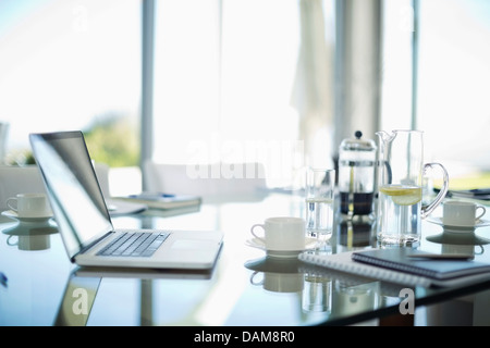 Laptop, Kaffeetassen und Notebooks auf Schreibtisch Stockfoto