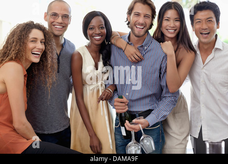 Freunde lächelnd zusammen auf party Stockfoto