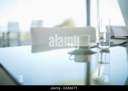 Kaffeetasse und Wasserglas am Besprechungstisch Stockfoto