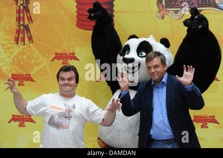 US-Schauspieler Jack Black (L) und deutsche Schauspieler Hape Kerkeling posieren mit einem Panda-Figur bei einem Fototermin bei der "Kung Fu Panda 2"-Präsentation in Berlin, Deutschland, 7. Juni 2011. Der Film wird am 16. Juni in deutschen Kinos sein. Foto: Jens Kalaene Stockfoto