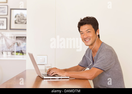 Mann mit Laptop am Tisch Stockfoto