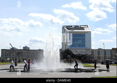 Kinder spielen in einem Brunnen vor der so genannten Humboldt-Box auf dem Schlossplatz in Berlin, Deutschland, 9. Juni 2011. Menschen können Informationen über den Wiederaufbau des Berliner Schlosses an der Humboldt-Box zu suchen. Foto: Jörg Carstensen Stockfoto