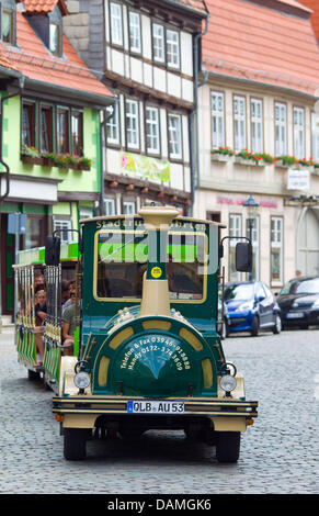 Gruppen von Touristen fahren auf einem kleinen Elektro Zug durch die Stadt Quedlinburg, Deutschland, 12. Juni 2011. Die alte Stadt Quedlinburg bietet Platz für mehr als 1,200 Fachwerkbauten und seit 1994.Photo eine eingetragene Weltkulturerbe von der UNESCO: Jens Wolf Stockfoto