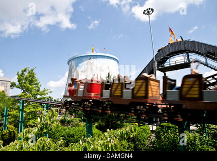 Besucher fahren Achterbahn vor einem ehemaligen Kühlturm im Freizeitpark "Wunderland Kalkar" in Kalkar, Deutschland, 9. Juni 2011. 1995 Niederländer Hennie van der meisten kaufte das ehemalige Kernkraftwerk "Schneller Brueter" und verwandelte es in ein Hotel und Freizeit-Center. Foto: Maximilian Haupt Stockfoto