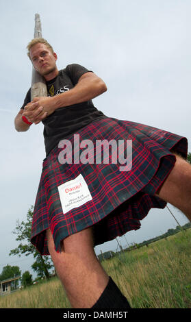 In Vorbereitung für den 3. Highland Festival hebt Kilt trägt Daniel Dorow einen Stamm in Fuerstenwalde, Deutschland, 15. Juni 2011. An den so genannten Highland Games vom 18. zum 19. Juni 2011 treten starke Männer in einem Kilt in Wettbewerben wie Baumstämme, Liftig Traktorreifen oder Kugelstoßen zu werfen. Mehr als 100 Participanrts werden erwartet. Foto: Patrick Pleul Stockfoto