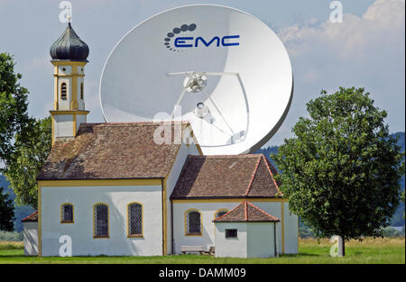 Die Wallfahrtskapelle St. Johann steht vor einer großen Parabolantenne der Erde Station in der Nähe von Raisting, Deutschland, 21. Juni 2011. Foto: Peter Kneffel Stockfoto