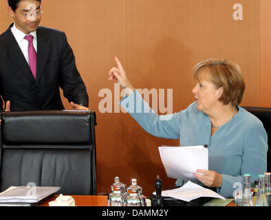 Bundeskanzlerin Angela Merkel spricht vor der Kabinettssitzung in der Staatskanzlei in Berlin, Deutschland, 22. Juni 2011 Bundesminister für Wirtschaft und Vizekanzler Philipp Roesler. Foto: WOLFGANG KUMM Stockfoto