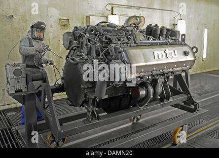 (DATEI) Eine Archivfoto vom 2. Februar 2010 zeigt einen Mitarbeiter die Tognum-Tochtergesellschaft MTU Malerei einen Motor von der Baureihe 1600 im Werk des Unternehmens in Überlingen, Deutschland. Daimler und Rolls-Royce haben 94 Prozent des Bestandes an der Motorenhersteller Tognum, laut Daimler am 24. Juni 2011 in Stuttgart erworben. Foto: Patrick Seeger Stockfoto