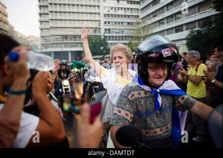 Menschen mit einem Konvoi von Motorrädern vor dem Parlament in Athen, 28. Juni 2011 unter Beweis stellen. Tausende Menschen demonstrierten gegen die Sparmaßnahmen, die der Europäischen Union sagt sind erforderlich, um eine globale Wirtschaftskrise zu vermeiden. Foto: Arno Burgi Stockfoto