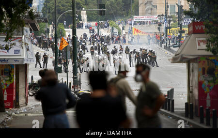 Demonstranten werfen Steinen bei Bereitschaftspolizei bei Zusammenstößen vor dem griechischen Parlament am zweiten Tag von einem 48-stündigen Generalstreik in Athen, Griechenland, Mittwoch, 29. Juni 2011. Millionen von Griechen nahmen an dem Streik zu neuen schweren Sparmaßnahmen zu widersetzen, die Teil eines Rahmens mittelfristige finanzpolitische Strategie 2012-2015 sind im Parlament am Mittwoch geschlossen werden soll. Stockfoto