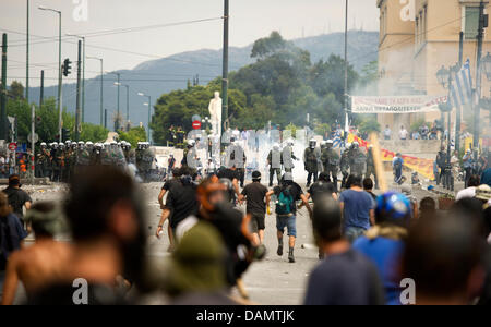 Demonstranten werfen Steinen bei Bereitschaftspolizei bei Zusammenstößen vor dem griechischen Parlament am zweiten Tag von einem 48-stündigen Generalstreik in Athen, Griechenland, Mittwoch, 29. Juni 2011. Millionen von Griechen nahmen an dem Streik zu neuen schweren Sparmaßnahmen zu widersetzen, die Teil eines Rahmens mittelfristige finanzpolitische Strategie 2012-2015 sind im Parlament am Mittwoch geschlossen werden soll. Stockfoto