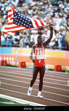 (Dpa Datei) - eine Archiv-Bild vom 4. August 1984, zeigt uns Leichtathlet Carl Lewis winken die Stars And Stripes während der Ausführung einer Ehrenrunde im Sportstadion in Los Angeles, USA. Carl Lewis, einer der bekanntesten Leichtathleten des 20. Jahrhunderts, feiert seinen 50. Geburtstag dieses Freitag, 1. Juli 2011. Foto: Dpa Stockfoto