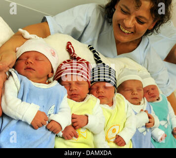 Die Neugeborenen Lilly Sophie liegen die Zwillingen Philip und Louis, Marco und Marlene (L-R) in den Armen von der Oberschwester der Entbindungsstation, Madelaine Birgel, an der Universitäts Frauenklinik in Leipzig, Deutschland, 22. Juni 2011. Im Vergleich zu 2010 zeichnet sich ein Trend zu einer steigenden Geburtenrate im Krankenhaus. Bis Mitte Juni wurden mehr als 1.000 Kinder in der Frauenklinik geboren. Foto: Stockfoto