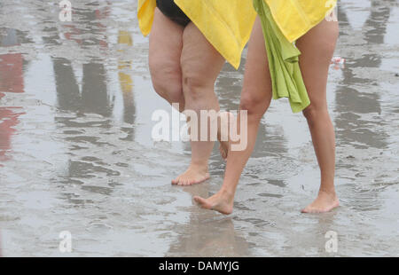 Frauen gehen am Strand des Seebades in Stralsund, Deutschland, 2. Juli 2011. Wegen Sturmwarnung die älteste Langstrecken Schwimmen Deutschlands, der 47. internationalen Sund ca. 2.300 Meter schwimmen abgesagt werden. Das Wetter in Norddeutschland wird durch Temperaturen um 16 Grad Celsius und Regen bestimmt. Foto: STEFAN SAUER Stockfoto