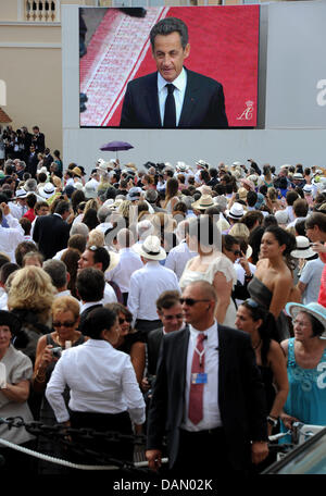 Der französische Präsident Nicolas Sarkozy wird auf einem Bildschirm vor die kirchliche Trauung von Fürst Albert II. und Prinzessin Charlene in dem Fürstenpalast in Monaco, 2. Juli 2011 gesehen. Rund 3500 Gästen sollen die Zeremonie in der Main-Innenhof des Palastes zu folgen. Foto: Frank Mai dpa Stockfoto