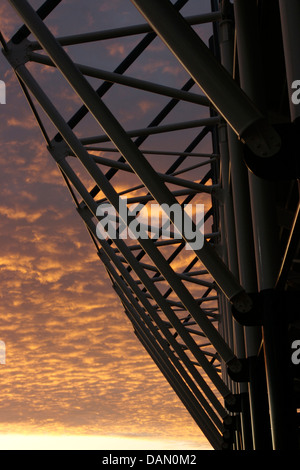 Die fast Silhouette Stand ein Fußball-Stadion hat Sonnenaufgang Wolken dahinter. Stockfoto