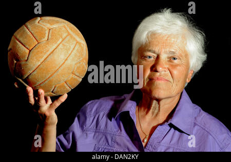 (Dpa-Datei) - ein Datei-Bild vom 17. Juni 2011 des deutschen Frauenfußballs pioneer Baerbel Wohlleben mit einem Lederball aus den 50er Jahren in Frankfurt Am Main, Deutschland. Wie ein TuS Woerrstadt Spieler Wohlleben gewann das erste offizielle Finale match für die deutsche Meisterschaft gegen Eintracht Gelsenkirchen-Erle 1974. Sie erzielte das 3:0 mit einem fulminanten 20-Meter-Schuss knapp unterhalb der crossba Stockfoto