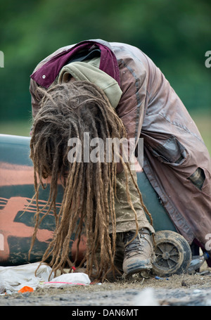 Glastonbury 2013 - Rastalocken einheimischer schläft auf einem umgedrehten Wheelie-bin am Steinkreis. Stockfoto