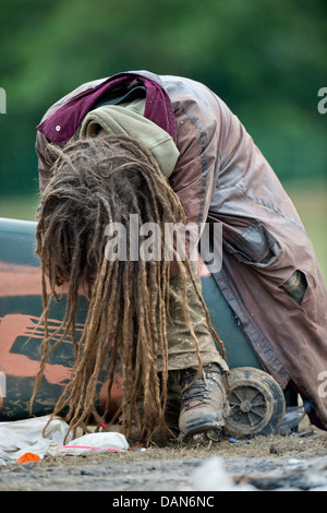 Glastonbury 2013 - Rastalocken einheimischer schläft auf einem umgedrehten Wheelie-bin am Steinkreis. Stockfoto