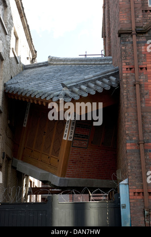 Chinesisches Haus eingeklemmt zwischen hohen Gebäuden Kunst im öffentlichen Raum Stockfoto