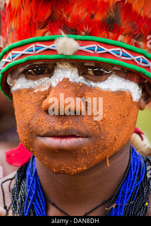 Junger Mann mit seinem Gesicht gemalt und tragen eine Stammes-Kopfbedeckung, Goroka Festival, Papua-Neu-Guinea Stockfoto