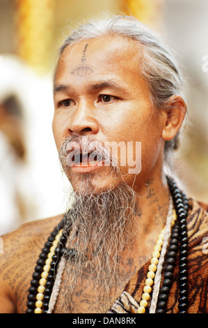 Stark tätowierte animistische Eremiten Heilungsgebete sagen und sagen Vermögen am Doi Suthp buddhistischer Tempel in Chiang Mai, Thailand. Stockfoto