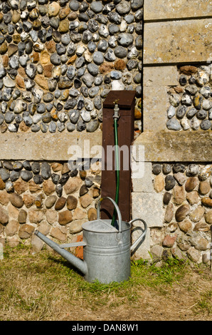 Gießkanne und Gartenschlauch Stockfoto