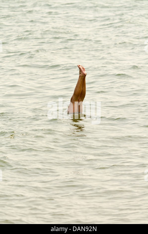 Mann tut Handstand im Meer Stockfoto